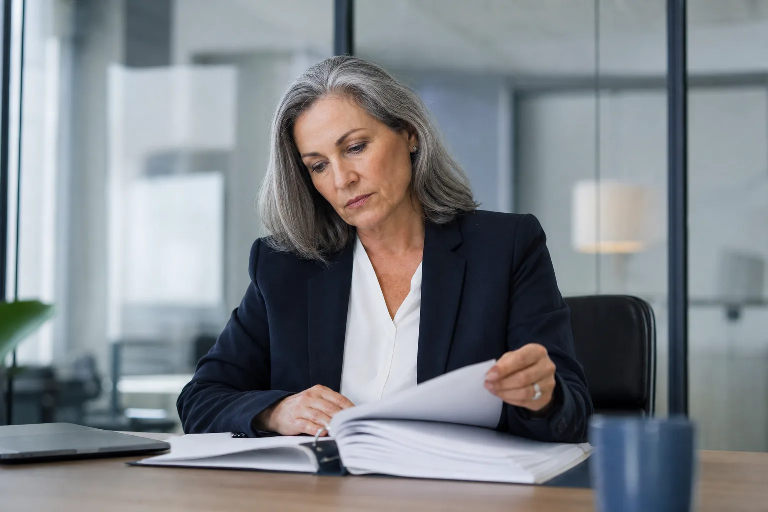 Compliance officer reviewing an access policy binder in a quiet office