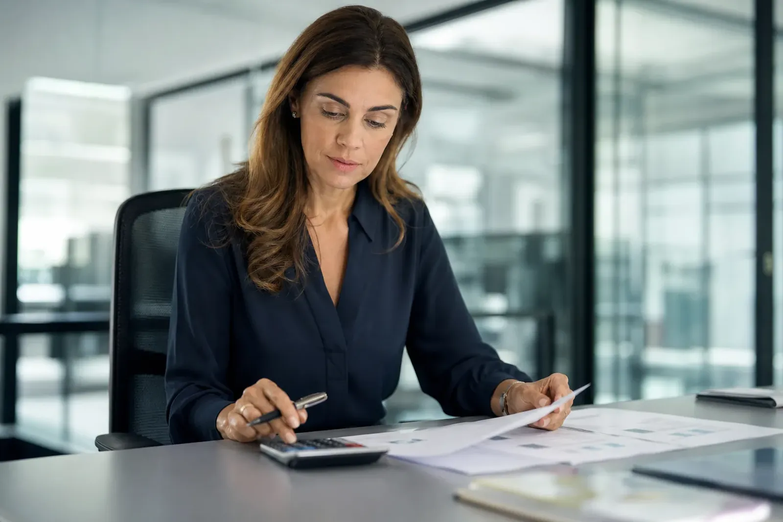 Finance manager reviewing a small business software budget with printed figures